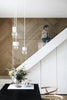 A white dining room with a HAPPY HOMES CREATIVE wooden wall by COZY.
