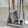 A close-up of the ELDVARM EMMA FIRE TOOL COMPANION SET shows the gray metal shovel, brush, and tongs arranged neatly on a carpeted floor.