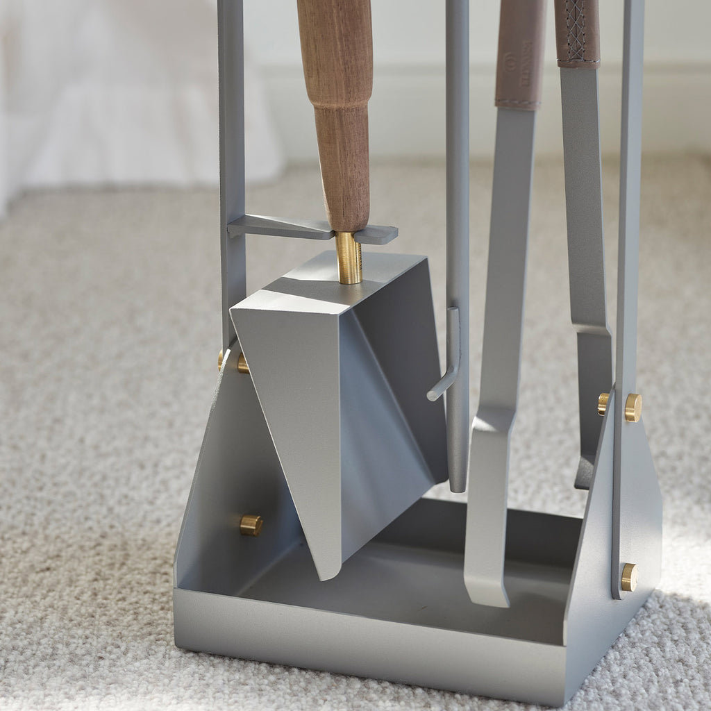 A close-up of the ELDVARM EMMA FIRE TOOL COMPANION SET shows the gray metal shovel, brush, and tongs arranged neatly on a carpeted floor.