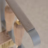 Close-up of a leather-wrapped handle on the metallic EMMA FIRE TOOL COMPANION SET by ELDVARM, embossed with "LUXURY," featuring wood and brass accents—an elegant upgrade for any fireplace tool set.