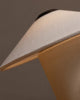 Close-up of a beige lampshade and part of the FUTÉ Table Lamp by LYFA against a gray background, highlighting its textured, angular design inspired by Danish aesthetics.