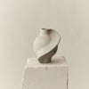 A PIROUT VASE VINTAGE GLAZE by LOUISE ROE displayed on top of a block of concrete.