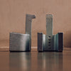Two LAKER STUDIO cast iron LUG DOORSTOPS sitting on a table next to each other.