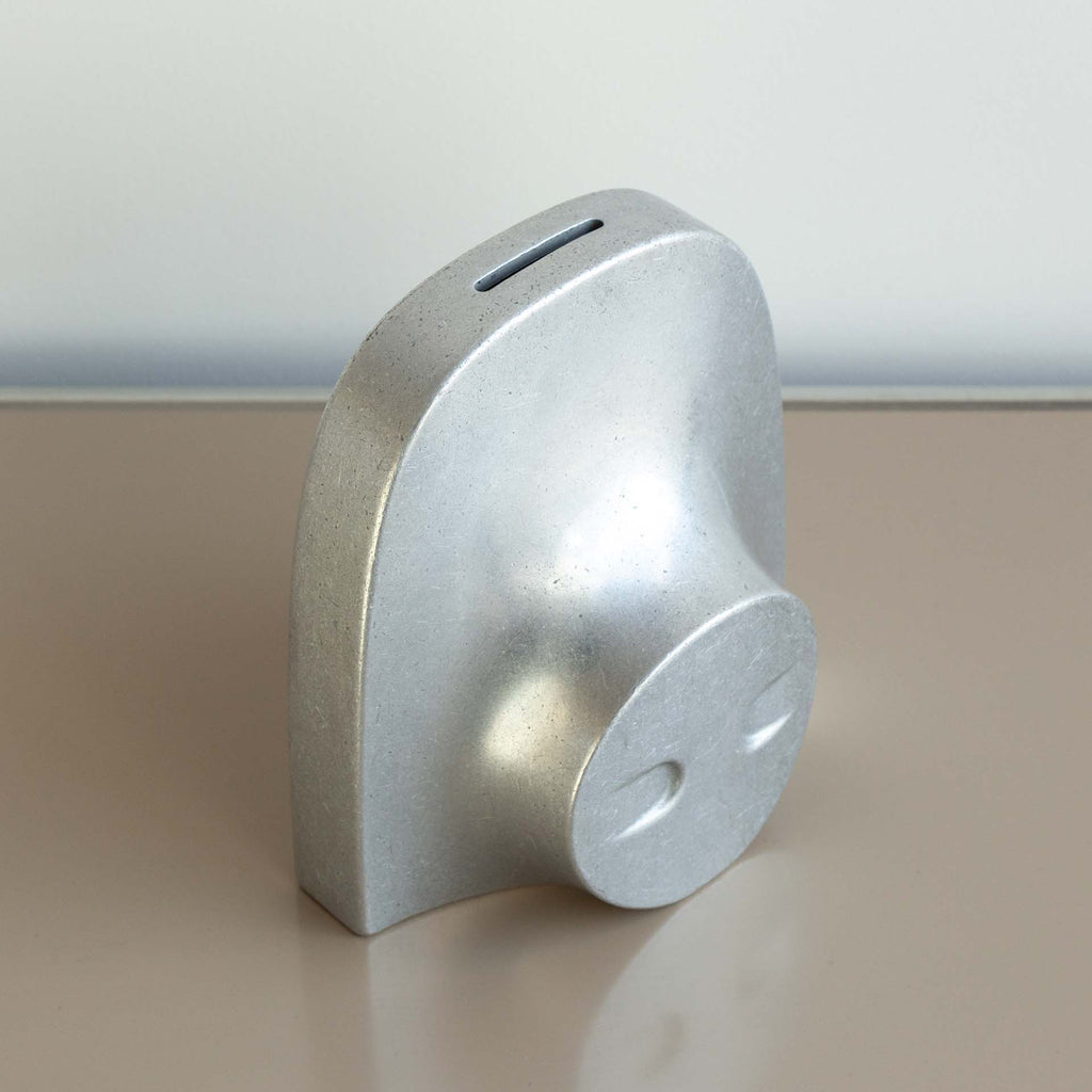 A COINK PIGGY BANK BOOKEND from STUDIO HENRY WILSON sitting on a table.