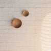 Two ORIGIN MADE ADÃO COAT PEGs gracefully suspended on a minimalist white brick wall at Gestalt Haus.