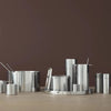 A set of STELTON pots and pans on a wooden table by ARNE JACOBSEN SERVING TRAY.