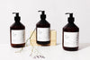 Three HETKINEN hand soap bottles on a wooden table.