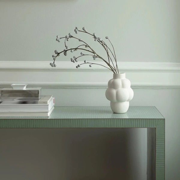 A table with a Louise Roe Ceramic Balloon Vase 04 Petite and books on it at the Gestalt Haus.