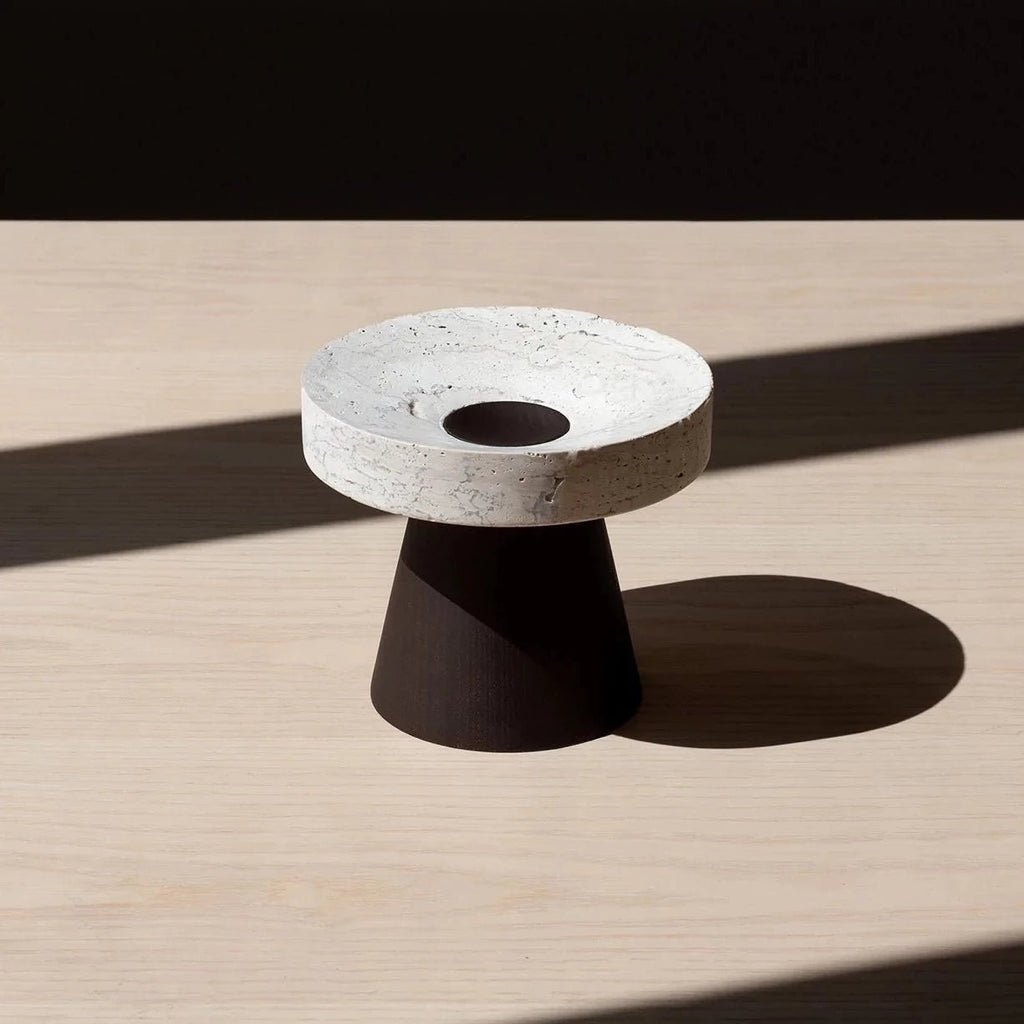 An ORIGIN MADE COLISEU PEDESTALS candle holder on a wooden table.