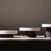 Three COLISEU PEDESTALS by ORIGIN MADE on top of a table.