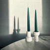 Two COMO TEA LIGHT HOLDERS by AARON PROBYN are sitting on a table in front of a mirror at Gestalt Haus.