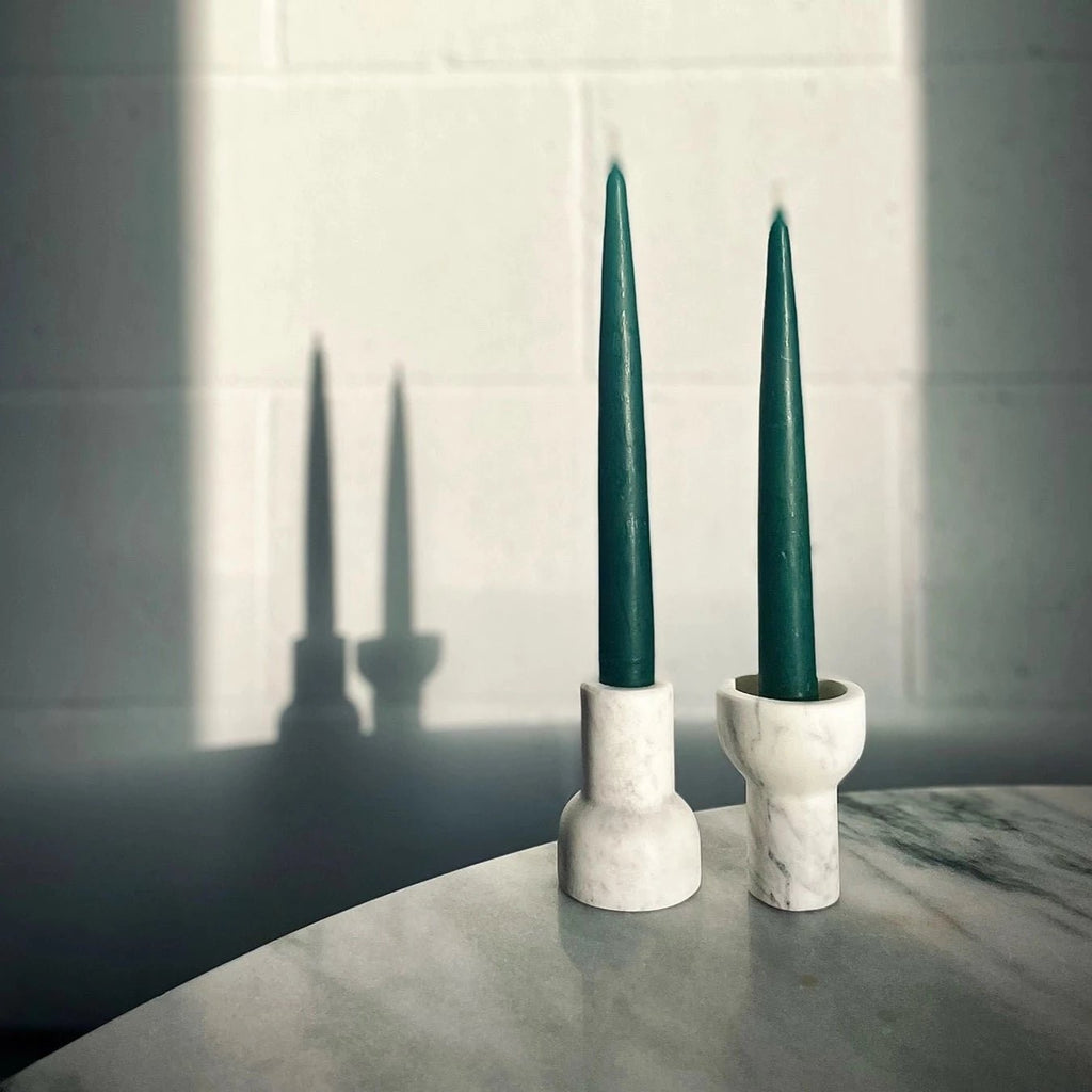 Two COMO TEA LIGHT HOLDERS by AARON PROBYN are sitting on a table in front of a mirror at Gestalt Haus.