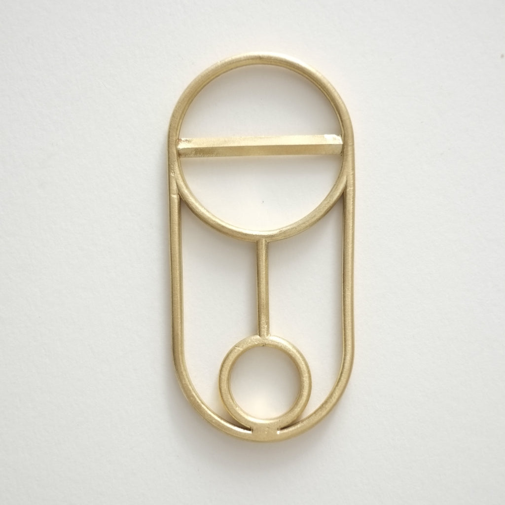 A CREST BOTTLE OPENER with a circle in the middle.