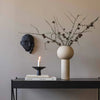 A DREAMER SCULPTURE by COOEE with a candle on a table next to a wall at Gestalt Haus.