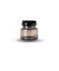 A Louise Roe glass jar with a black lid on a white background, inspired by the minimalist essence of Gestalt Haus.