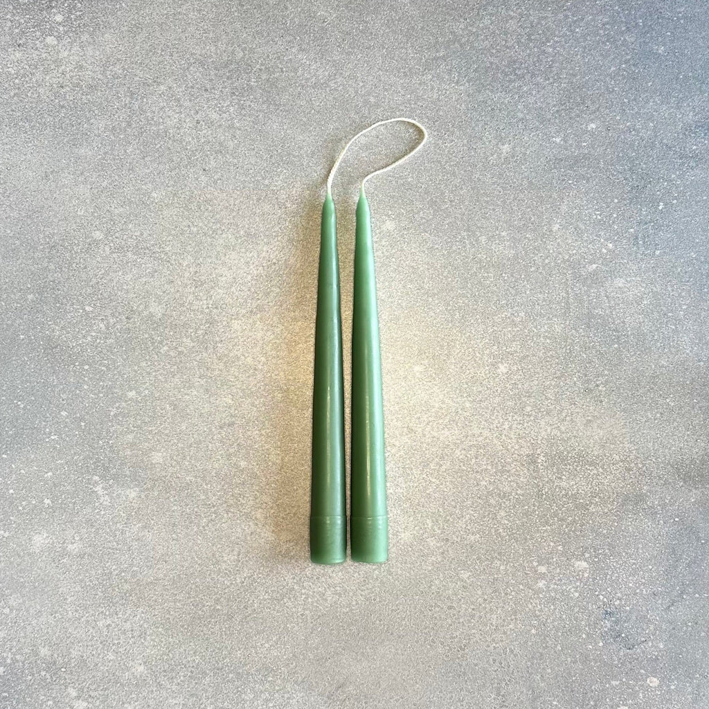Two DANICA DESIGNS HAND-DIPPED TAPER CANDLES adorned in a Gestalt Haus, hanging on a wall.