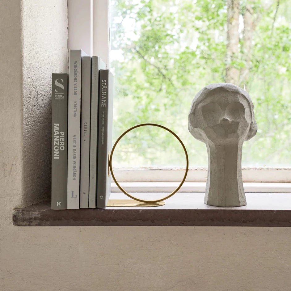 A window sill adorned with books, a vase, and a COOEE OLLIE HEAD SCULPTURE in the Gestalt Haus style.