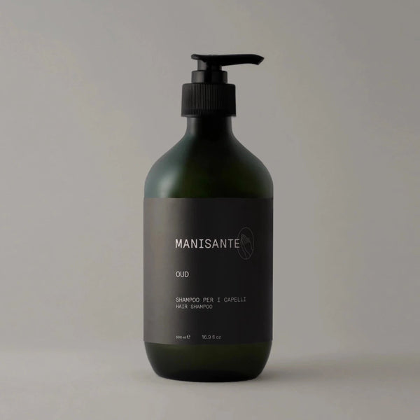 A bottle of OUD SHAMPOO by MANISANTE on a grey background with Gestalt Haus influence.