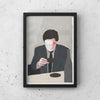 A framed print of TAKING A BREAK SERIES "AFTER DINNER" by CAN FAMILY, featuring a man in a suit sitting at a Gestalt Haus table.